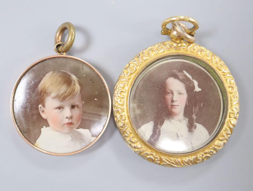 A late Victorian 9ct double sided glazed locket, 33mm and other yellow metal mounted glazed pendant, 26mm,